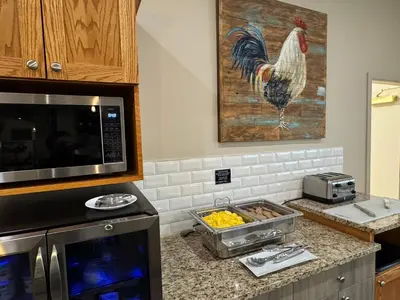 a kitchen with a rooster painting on the wall at Western Budget Motel Leduc #3 in Leduc