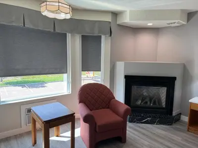 a living room with a chair and a fireplace at Western Budget Motel Leduc #3 in Leduc