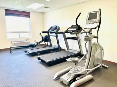 a gym with three exercise bikes and a treadmill at Days Inn by Wyndham Grande Prairie in Grande Prairie