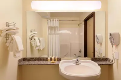 a bathroom with a sink and a large mirror at Days Inn by Wyndham Grande Prairie in Grande Prairie