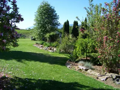 a garden with trees and flowers on a lawn at Bavarian Orchard Motel in Creston