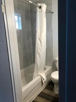 a bathroom with a white tub and a toilet at Bavarian Orchard Motel in Creston