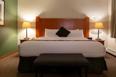 a large bed in a hotel room with two lamps at Whistler's Inn in Jasper