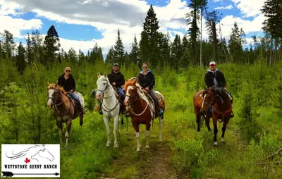 a group of people riding horses in a field at Wettstone Guest Ranch in Bridge Lake