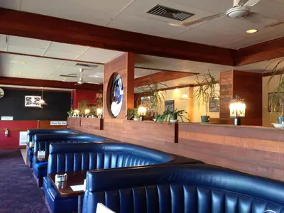 a row of blue leather chairs in a restaurant at Moby Dick Inn in Prince Rupert
