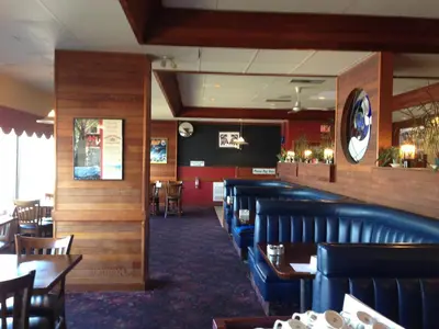 a dining room with blue chairs and tables in a restaurant at Moby Dick Inn in Prince Rupert