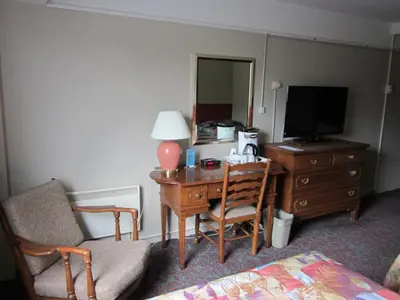 a room with a desk with a television and a chair at Moby Dick Inn in Prince Rupert