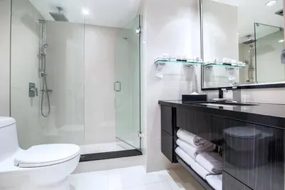 a bathroom with a shower and a toilet and a sink at Granville Island Hotel in Vancouver
