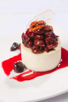 a cake topped with cherries on a red plate at Granville Island Hotel in Vancouver