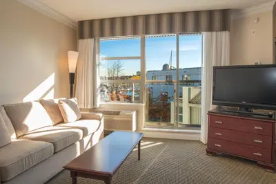 a living room with a couch and a flat screen tv at Granville Island Hotel in Vancouver