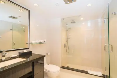 a bathroom with a toilet and a glass shower at Granville Island Hotel in Vancouver