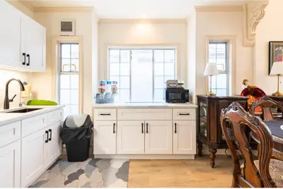 a kitchen with white cabinets and a sink at Go House in Richmond
