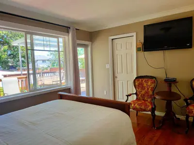 a bedroom with a bed and a television and a chair at Semi Centre House in White Rock