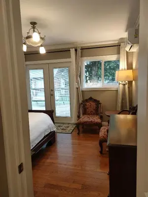 a bedroom with a bed and a chair and windows at Semi Centre House in White Rock