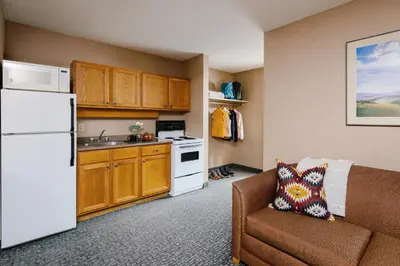 a small kitchen with a couch and a white refrigerator at Lobstick Lodge in Jasper