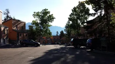 a street with cars parked in a parking lot at Douglas Fir Resort & Chalets in Banff