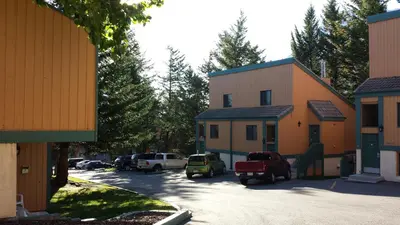 a group of buildings with cars parked in a parking lot at Douglas Fir Resort & Chalets in Banff