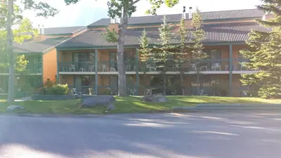 a large building with rocks in front of it at Douglas Fir Resort & Chalets in Banff
