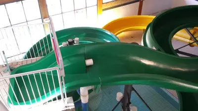 a playground with a green slide in a room at Douglas Fir Resort & Chalets in Banff