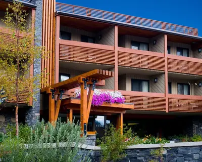 an apartment building with a bench in front of it at Banff Aspen Lodge in Banff