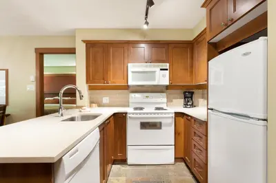 a kitchen with white appliances and wooden cabinets at Horstman House by Whistler Premier in Whistler