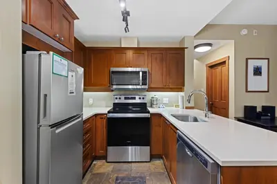 a kitchen with stainless steel appliances and wooden cabinets at Horstman House by Whistler Premier in Whistler