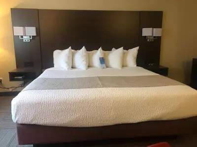 a large bed with white pillows in a hotel room at Days Inn by Wyndham Hinton in Hinton