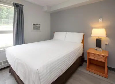 a bedroom with a large white bed and a window at Coast Hinton Hotel in Hinton