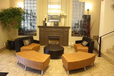 a living room with a fireplace and chairs and a tv at The Royal Anne Hotel in Kelowna
