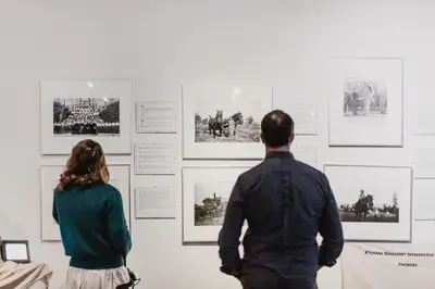 a man and a woman looking at a wall with pictures at St. Eugene Golf Resort & Casino in Cranbrook