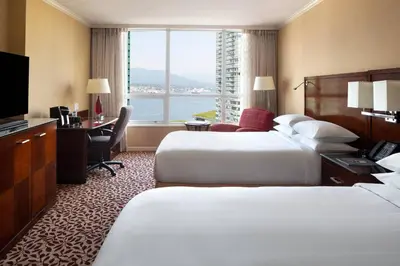 a hotel room with two beds and a desk and a window at Vancouver Marriott Pinnacle Downtown Hotel in Vancouver