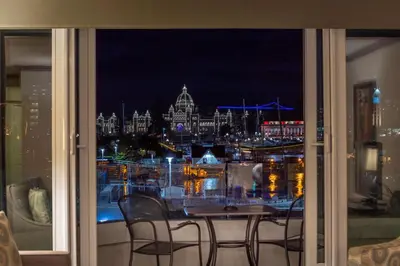 a view of a city at night from a window at Victoria Regent Waterfront Hotel & Suites in Victoria