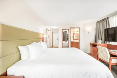 a hotel room with a large bed and a desk at Victoria Regent Waterfront Hotel & Suites in Victoria