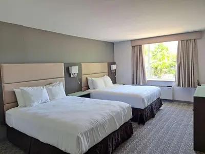 a hotel room with two beds and a window at Best Western Plus Vancouver Airport Hotel in Vancouver