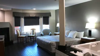 a hotel room with a bed and a bathroom at Western Budget Motel #1 Leduc/Nisku in Leduc