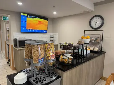 a kitchen with a counter with food and a clock at Western Budget Motel #1 Leduc/Nisku in Leduc