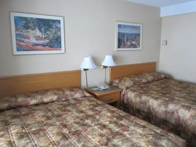 a hotel room with two beds and two lamps at Star Lodge in Kamloops