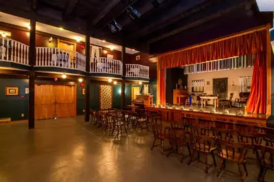 a large room with a bar with chairs and tables at Three Valley Lake Chateau in Revelstoke