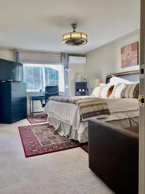 a bedroom with a bed and a desk and a window at Jessicahouse ltd. in Richmond