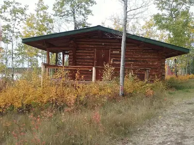 a log cabin in the middle of a field at Eagle Bear Lodge in Tatla Lake