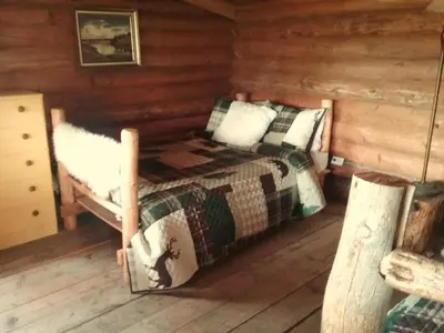 a bedroom with a bed in a log cabin at Eagle Bear Lodge in Tatla Lake
