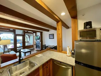a kitchen with a sink and a refrigerator at Great Condo In Excellent Location - Waterfront Building - Seaside in Ucluelet