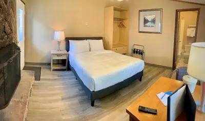 a bedroom with a bed and a table with a lamp at Sunwapta Falls Rocky Mountain Lodge in Jasper