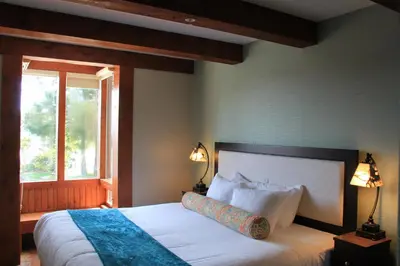 a bedroom with a bed with white sheets and a window at Beautiful Condo In A Great Location, Oceanfront Complex - Oe in Ucluelet