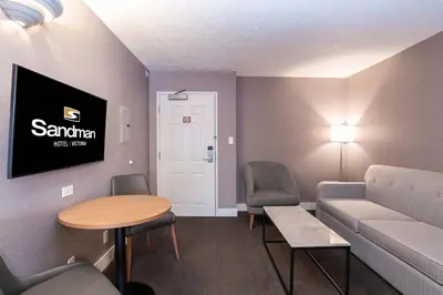a waiting room with a couch and a table and chairs at Sandman Hotel Victoria in Victoria