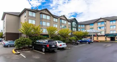 a large building with cars parked in a parking lot at Sandman Hotel Victoria in Victoria