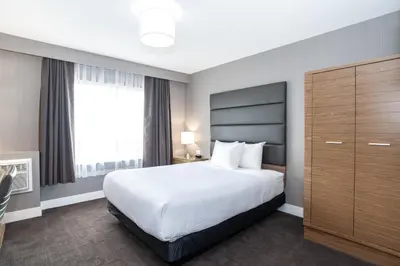 a bedroom with a large bed and a large window at Sandman Hotel Grande Prairie in Grande Prairie