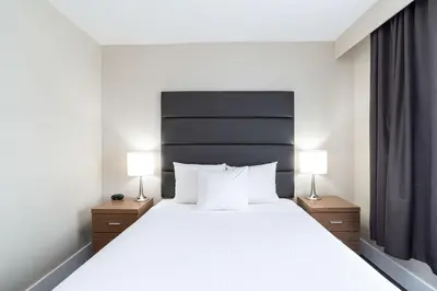 a bedroom with a large bed with two lamps at Sandman Hotel Grande Prairie in Grande Prairie
