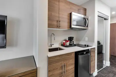 a small kitchen with a sink and a microwave at Sandman Hotel Grande Prairie in Grande Prairie