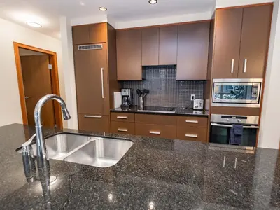 a kitchen with a sink and a counter at Sutton Place Hotel Revelstoke Mountain Resort in Revelstoke